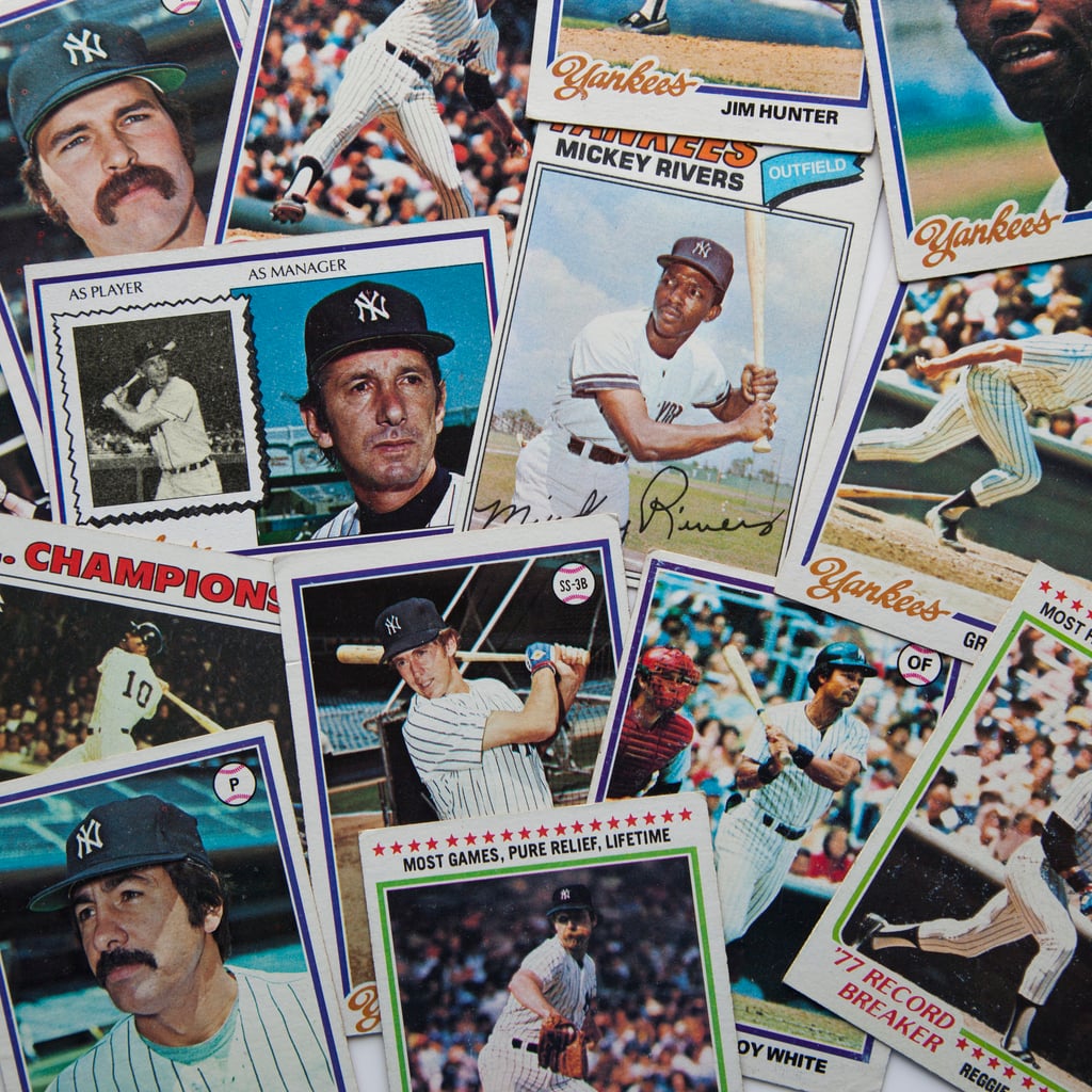 A scattered collection of vintage New York Yankees baseball cards featuring various players in Yankees uniforms, including close-ups and action shots—some with names and signatures visible—showcases one of the most expensive hobbies for passionate collectors.