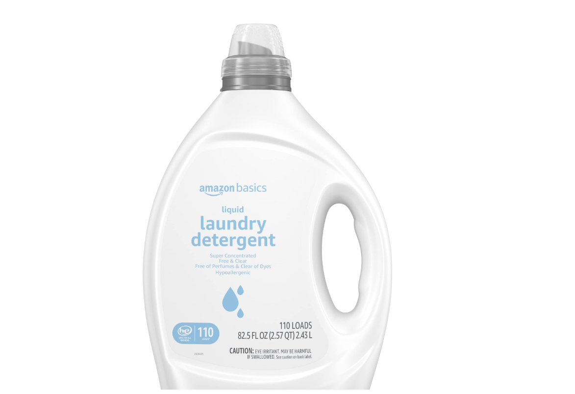 A large white bottle of Amazon Basics liquid laundry detergent, labeled as super concentrated, hypoallergenic, free of perfumes and dyes, 82.5 fl oz, with a clear cap and handle.