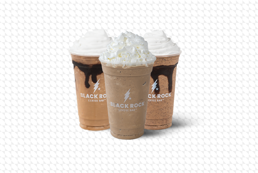 Three iced blended drinks in clear cups with whipped cream on top, featuring the Black Rock Coffee Bar logo. The drinks have chocolate drizzle and are set against a transparent background.