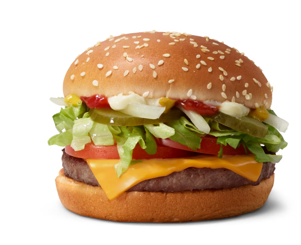 A cheeseburger with a sesame seed bun, beef patty, cheddar cheese, lettuce, tomato, pickles, onions, ketchup, and mustard on a white background.