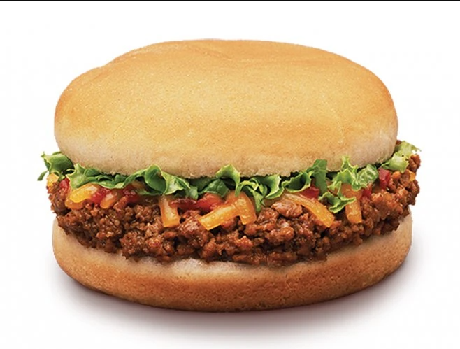 A sloppy joe sandwich with seasoned ground beef, shredded lettuce, and cheddar cheese on a plain hamburger bun.