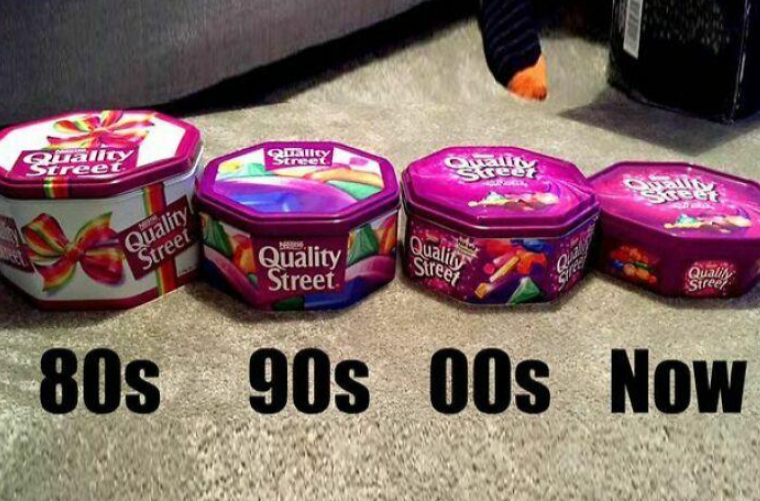 Four Quality Street tins from different decades—80s, 90s, 00s, and Now—showing a progression in size, with each tin becoming smaller over time.