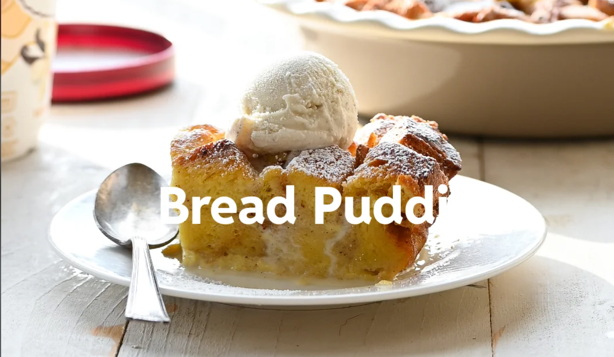 A slice of bread pudding topped with a scoop of vanilla ice cream sits on a white plate with a spoon, with “Bread Puddi” written across the image.