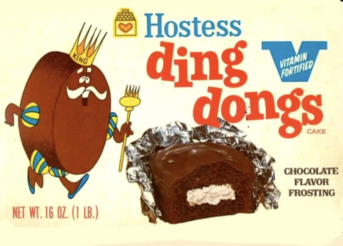 A vintage Hostess Ding Dongs cake box features a cartoon chocolate cake king, a foil-wrapped Ding Dong, and text promoting vitamin fortification and chocolate flavor frosting.