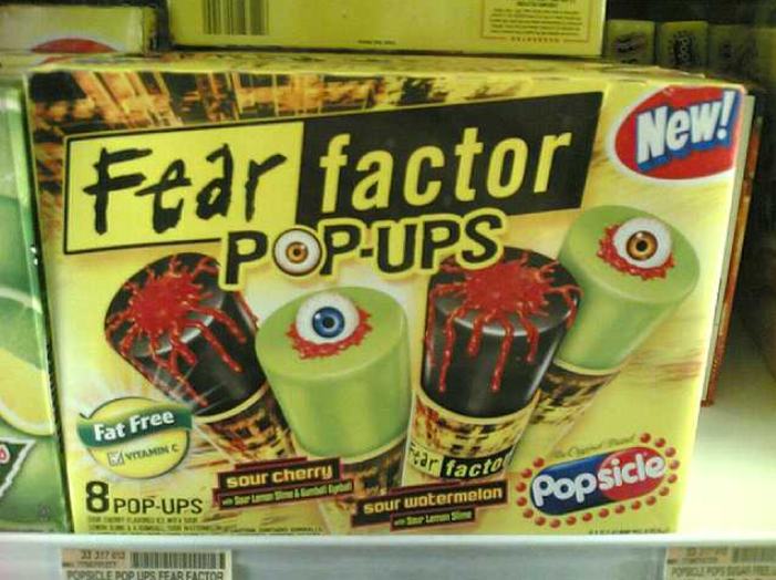 Box of "Fear Factor Pop-Ups" popsicles shaped to look like eyeballs with red goo, in sour cherry and sour watermelon flavors. The packaging is green and yellow with spooky graphics.