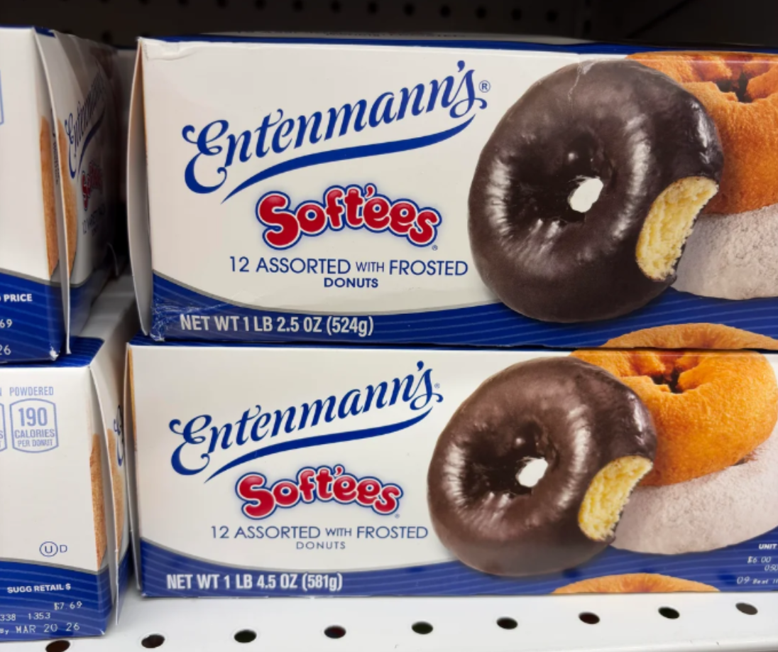 Boxes of Entenmann's Softees 12 assorted frosted donuts on a store shelf, showing chocolate and powdered varieties on the packaging—a familiar sight in photos of shrinking products, as customers notice reduced quantities in the same-sized boxes.
