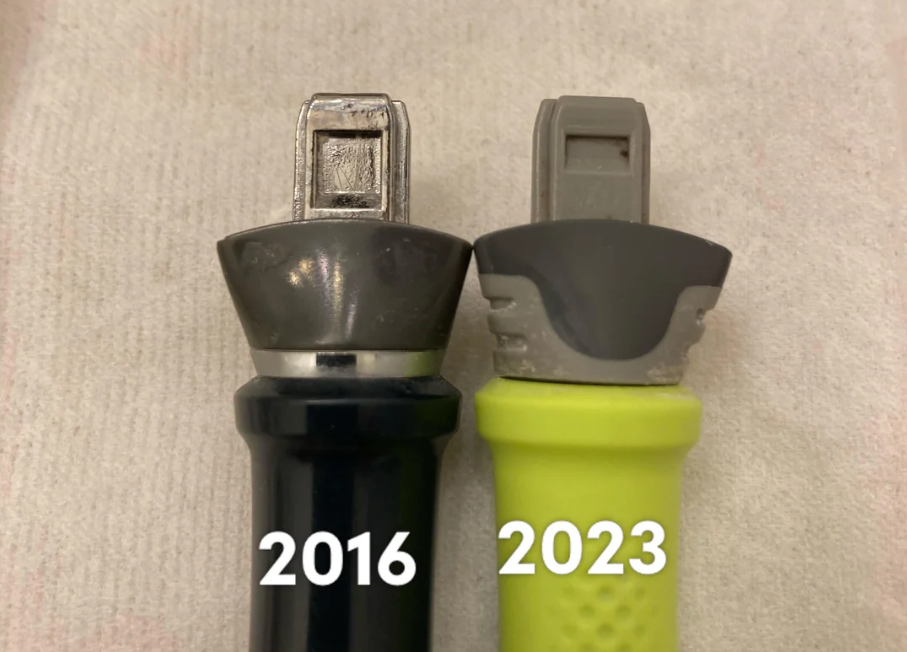 Two lancet devices are shown side by side on a light fabric background. The black device is labeled "2016" and the green device is labeled "2023," highlighting design changes over time. This comparison offers photos of shrinking products, illustrating how the size of these medical devices has evolved over the years.