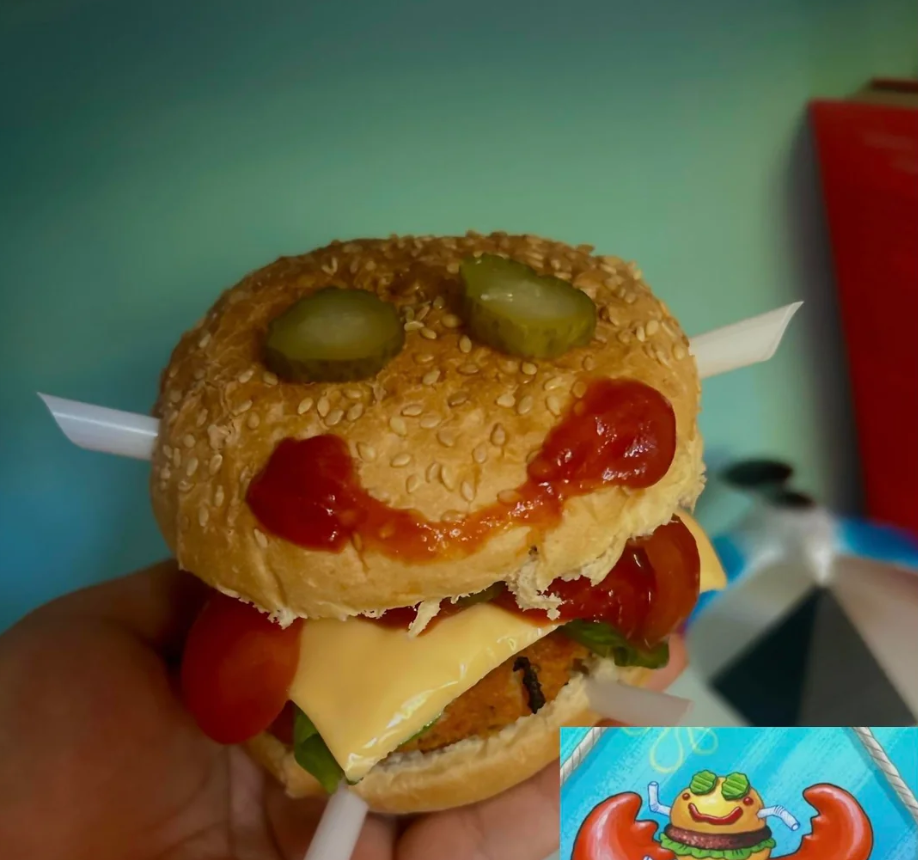 A hand holds a burger with pickle eyes, ketchup smile, and cheese slice, styled to look like Mr. Krabs from SpongeBob, with a reference image of Mr. Krabs in the lower right corner.
