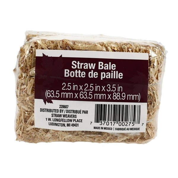 A small, rectangular straw bale with a label showing its dimensions in inches and millimeters, and distribution information, against a white background.