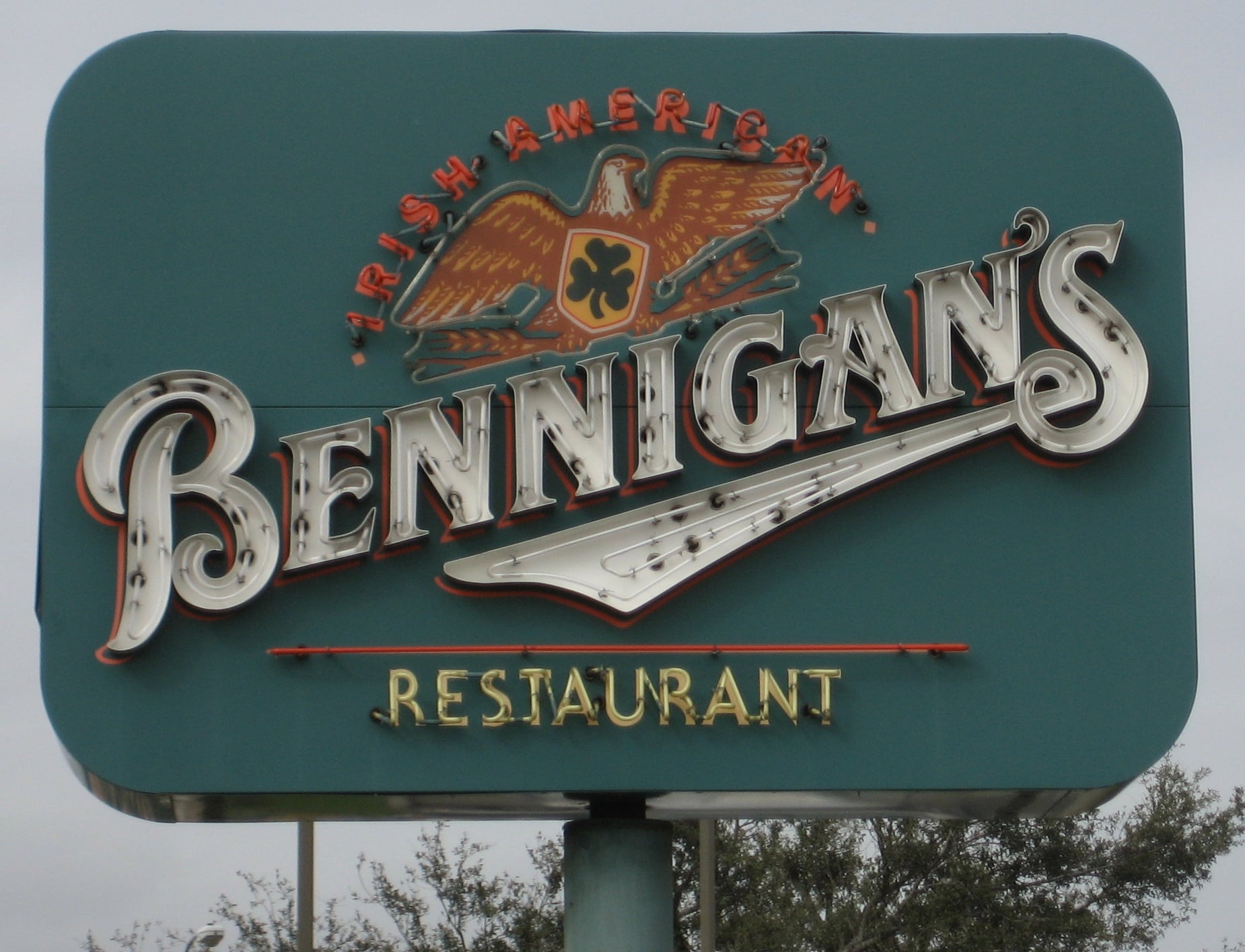 Restaurant chains going downhill. A green Bennigan's restaurant sign features an eagle, a shamrock, and the words "Irish American Restaurant" above the logo.