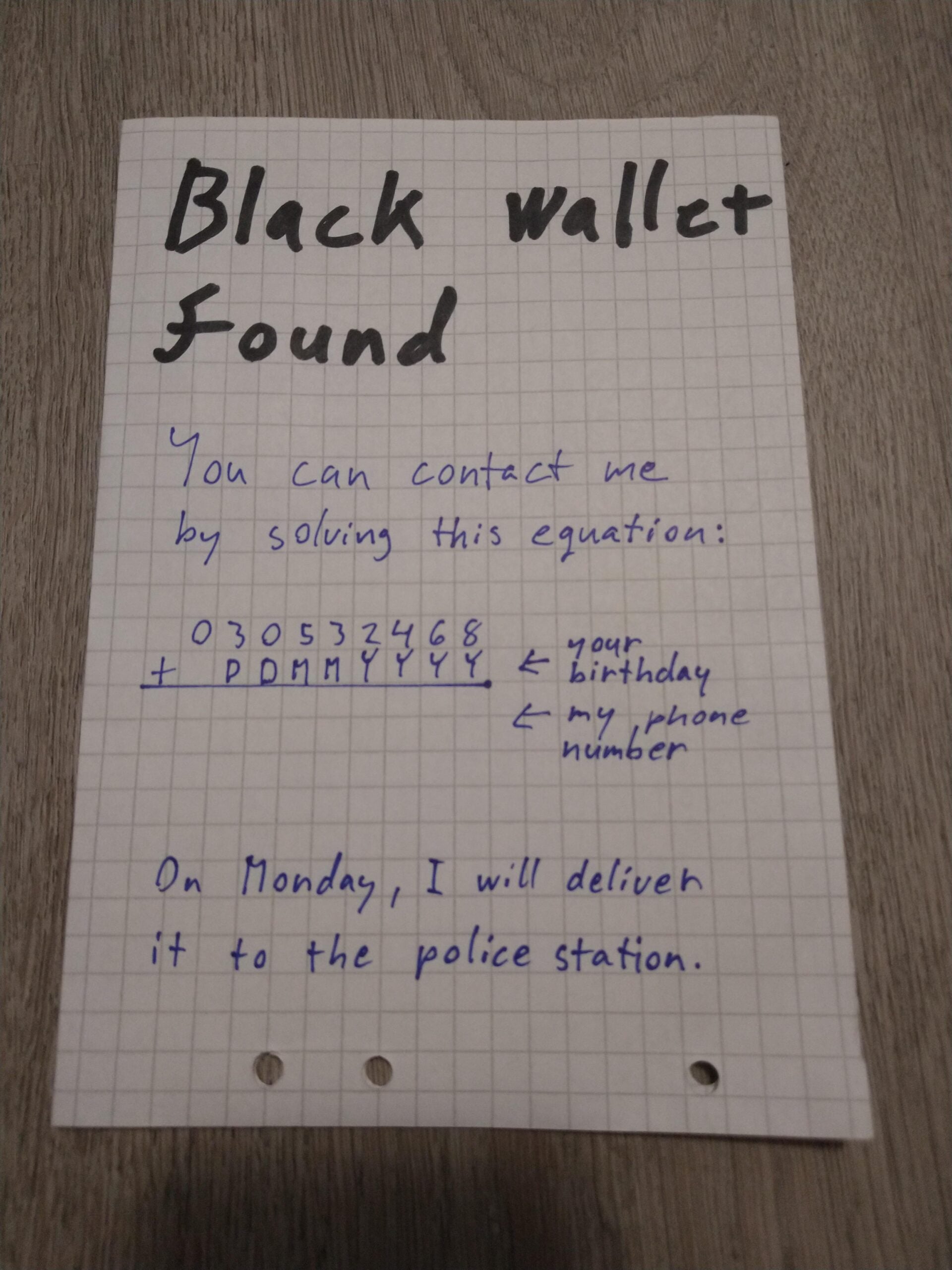 A handwritten note on graph paper says “Black wallet found.” It asks to solve an equation with a phone number and birthday to contact, and states the wallet will be delivered to the police station on Monday.