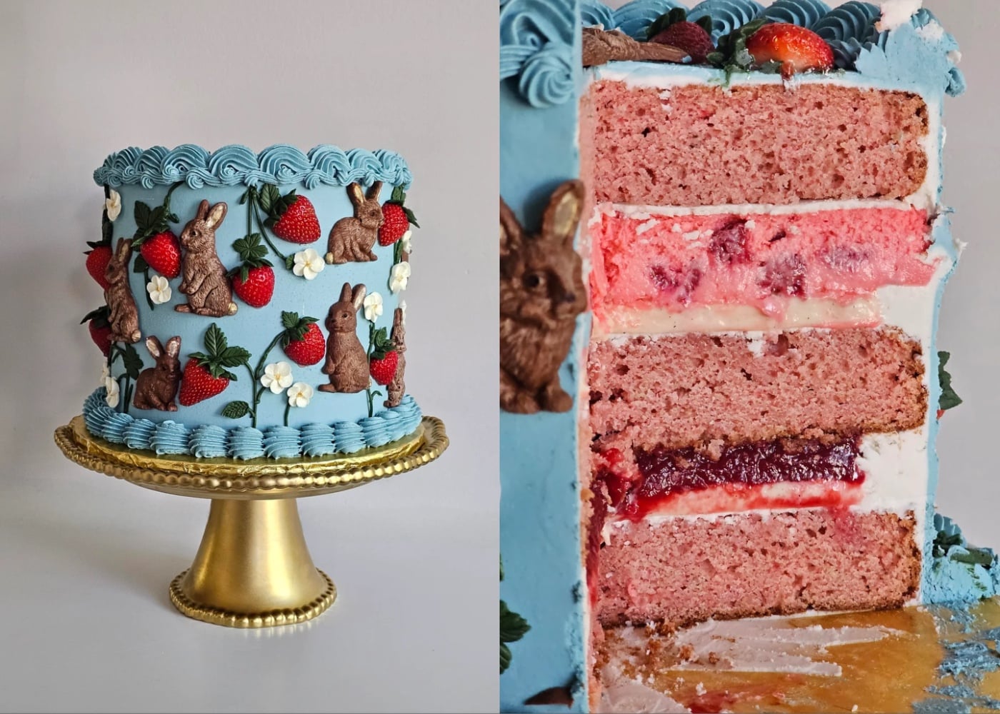 A blue frosted cake on a gold stand, decorated with chocolate bunnies, strawberries, and white flowers. The cut slice reveals pink cake layers with white, red, and pink fillings.