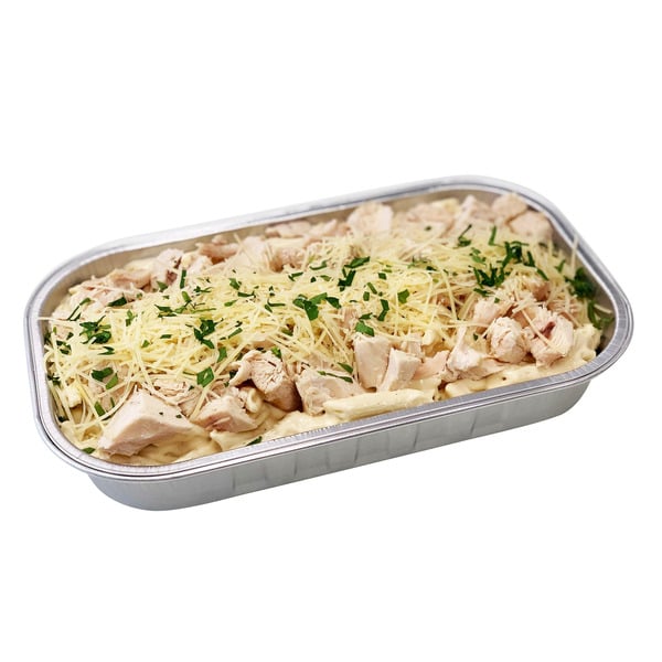 A foil container filled with pasta, topped with pieces of cooked chicken, shredded cheese, and a sprinkle of chopped herbs.