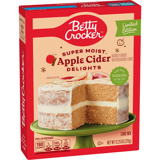 A box of Betty Crocker Super Moist Apple Cider Delights cake mix, featuring an image of a two-layer frosted cake with apple slices on top. The box is red and cream, labeled “Limited Edition.”