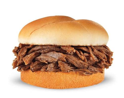 A sandwich with a soft white bun filled generously with shredded roast beef. The background is plain white, highlighting the sandwich.