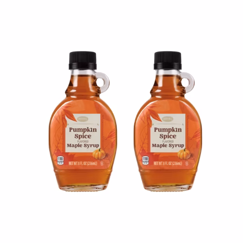 Two bottles of pumpkin spice flavored maple syrup with orange labels and black caps are placed side by side on a white background.