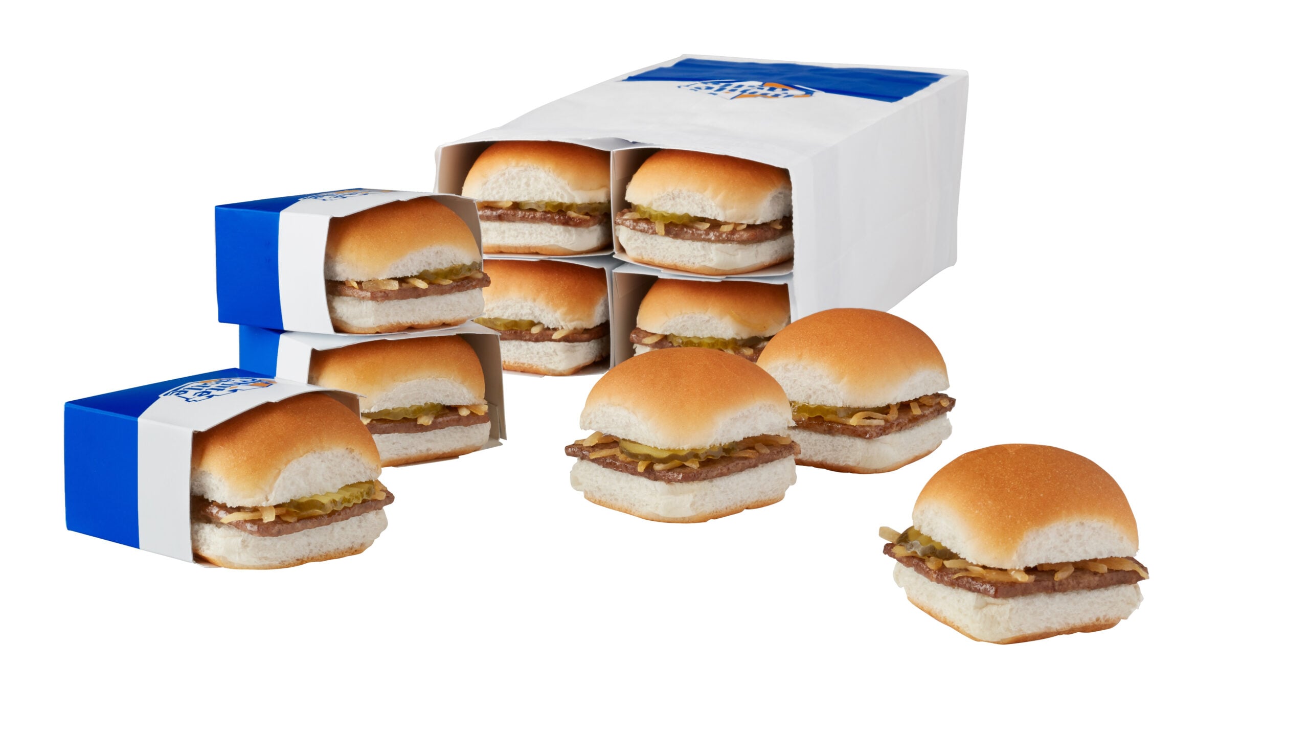 Eight small hamburgers with onions and pickles, some in blue and white slider boxes, some out of boxes, arranged around a White Castle branded paper bag on a white background.