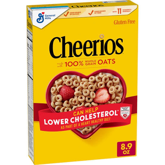 A yellow Cheerios cereal box with a heart-shaped bowl of cereal and strawberries. Text highlights that the cereal can help lower cholesterol. The box is labeled gluten free and weighs 8.9 oz.