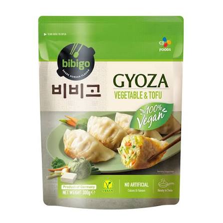 A green package of Bibigo Gyoza Vegetable & Tofu dumplings, labeled 100% vegan, with images of dumplings and vegetables on the front. The pack shows product info, vegan and no artificial claims.