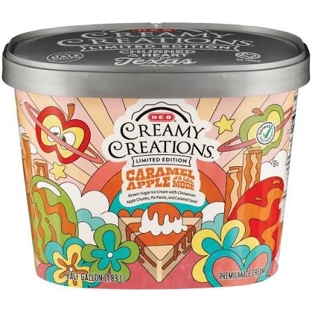 A colorful ice cream tub labeled “H-E-B Creamy Creations Caramel Apple Medley” features illustrated apples, caramel, and cinnamon sticks with a rainbow and cloud design on the packaging.
