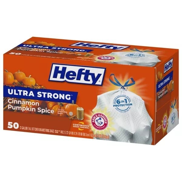 A box of Hefty Ultra Strong 13-gallon tall kitchen trash bags in Cinnamon Pumpkin Spice scent, featuring 50 bags and Arm & Hammer odor protection, with pumpkins and fall graphics on the packaging.