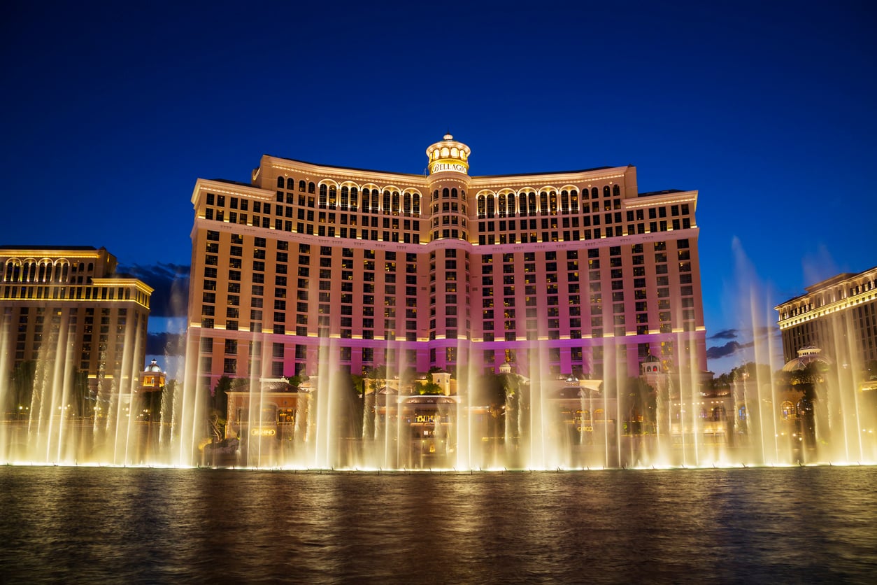 The Bellagio Hotel in Las Vegas is lit up at night with its famous water fountain show in the foreground, spraying illuminated water into the air—a spectacular sight that highlights one of the many fascinating facts about Las Vegas and its dazzling nightlife.