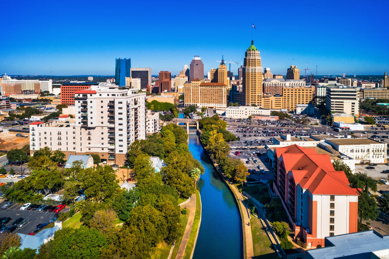 Aerial view of downtown San Antonio, Texas, showing the River Walk, tall buildings, and skyscrapers under a clear blue sky—one of the top travel spots boomers are learning to love.