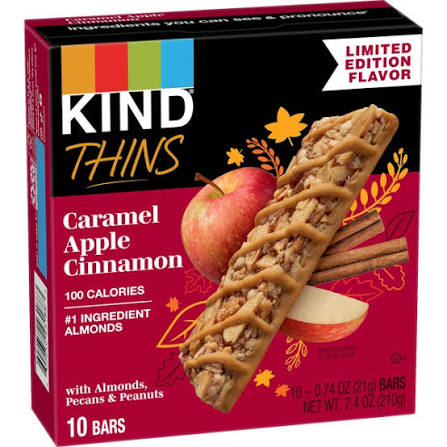 A box of KIND Thins Caramel Apple Cinnamon bars with an image of a granola bar, an apple, and text highlighting it as a limited edition flavor with 100 calories per bar.