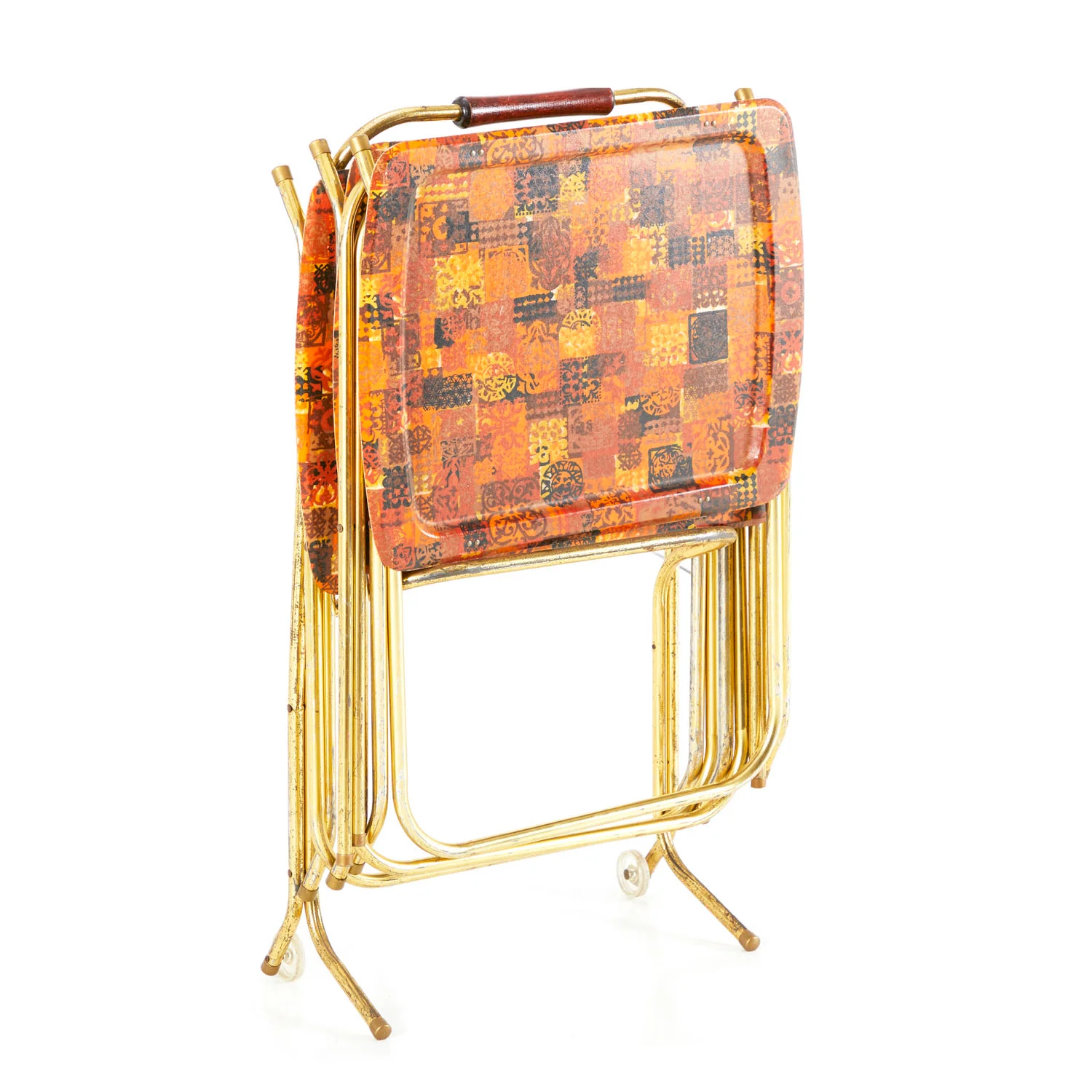 Four vintage folding TV trays with a red and orange checkered pattern, stacked on a gold metal stand with a handle on top. 1960s household items.