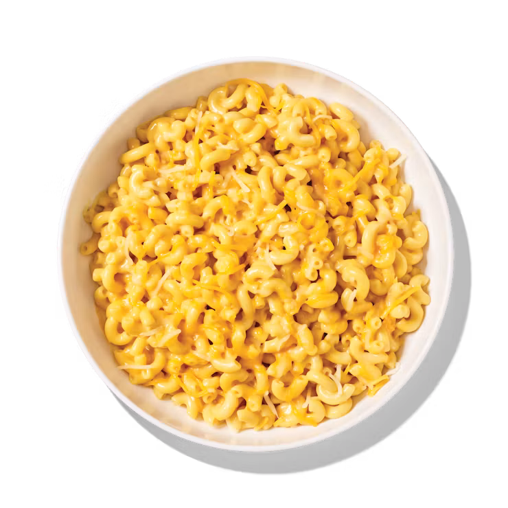 A white bowl filled with creamy macaroni and cheese, shown from above on a white background.