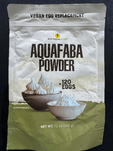 A bag labeled “Aquafaba Powder” with images of meringues and a bowl of powder. Text reads: “Vegan Egg Replacement,” “120 Eggs,” “Net Wt. 12 oz (340 g),” and “Rooted in Rare.”