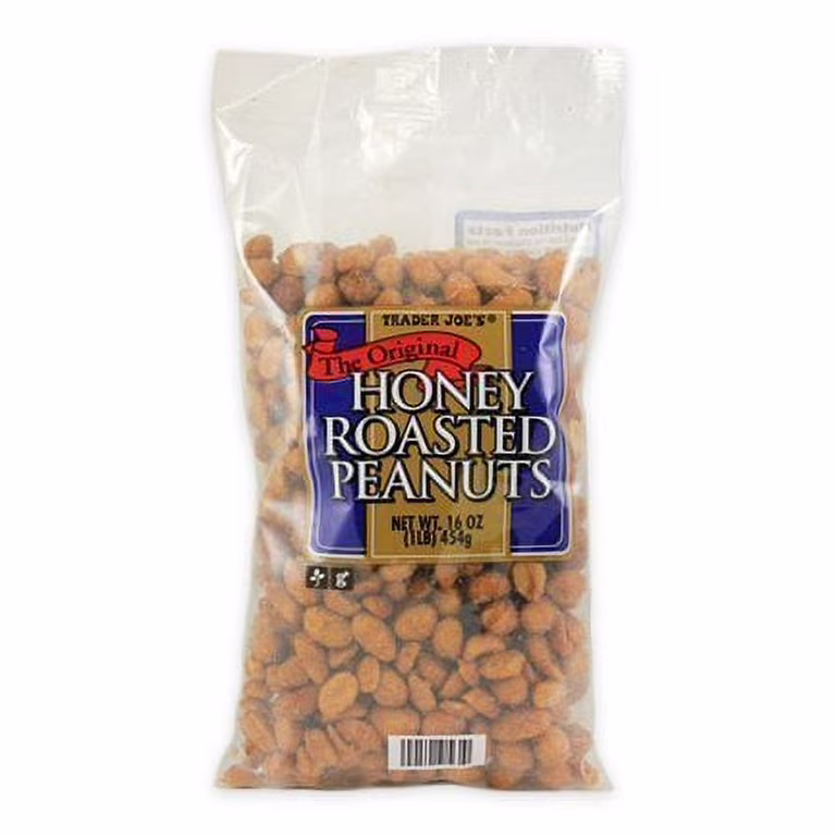 A clear bag of Trader Joe’s Honey Roasted Peanuts with a blue and yellow label, containing 16 oz (1 lb) of peanuts. The peanuts are visible through the packaging.