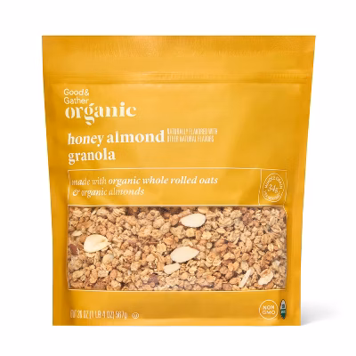 A yellow bag of Good & Gather Organic Honey Almond Granola with a clear window showing the granola and almond slices. The packaging highlights organic ingredients and non-GMO certification.