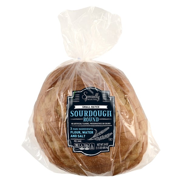 A loaf of sourdough bread in a clear plastic bag with a blue and black label that reads “Small Batch Sourdough Round.”