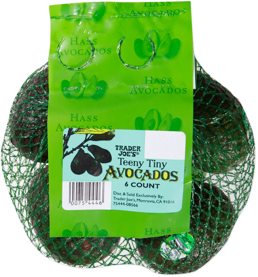 A netted bag labeled “Trader Joe’s Teeny Tiny Avocados, 6 count” with a green tag showing avocado illustrations and product details. Six small avocados are visible inside the green mesh bag. Best Trader Joe’s products.