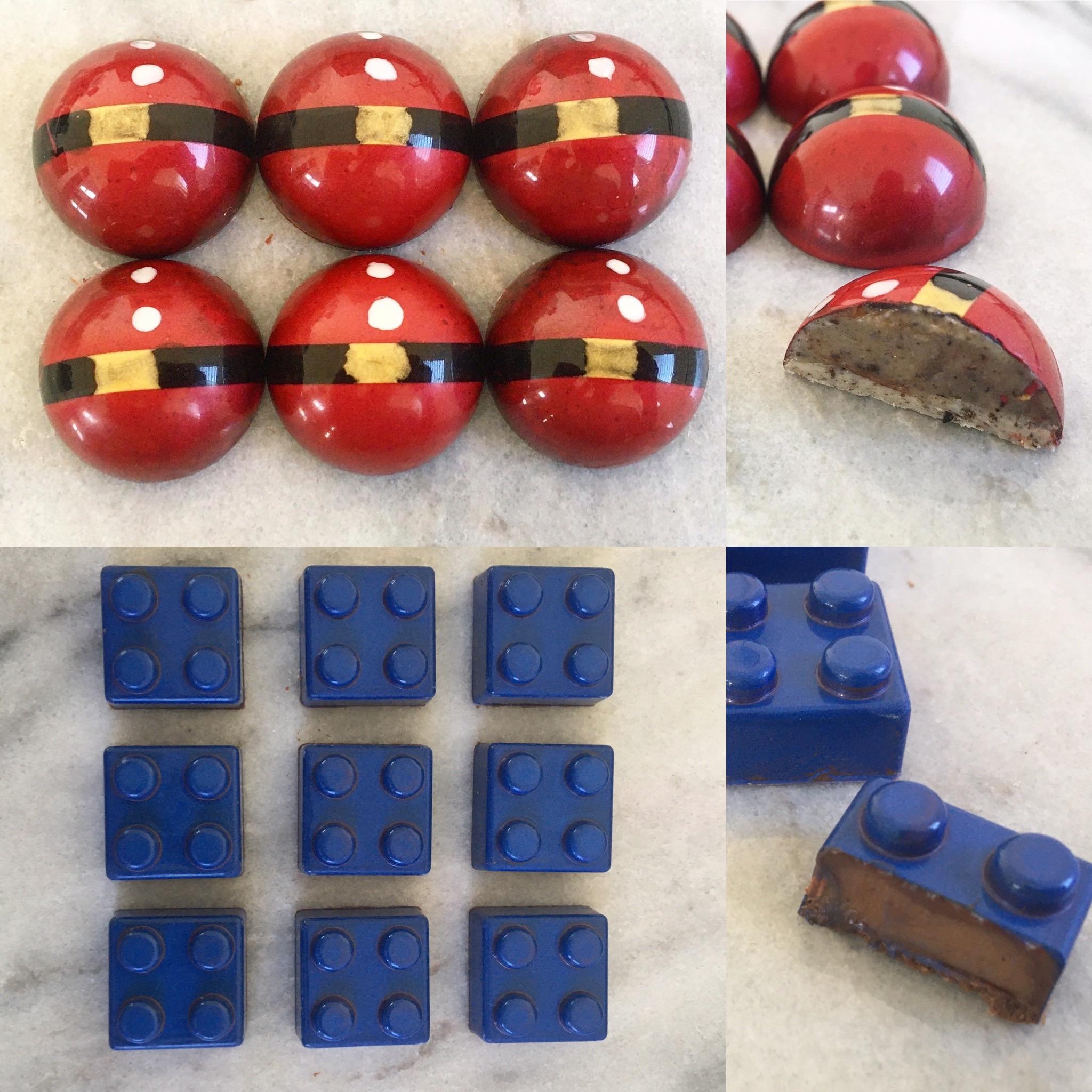 Top: Red and gold domed chocolates, one cut open showing filling. Bottom: Blue chocolates shaped like LEGO bricks, one cut open revealing a brown filling. Both are arranged neatly on a light surface.