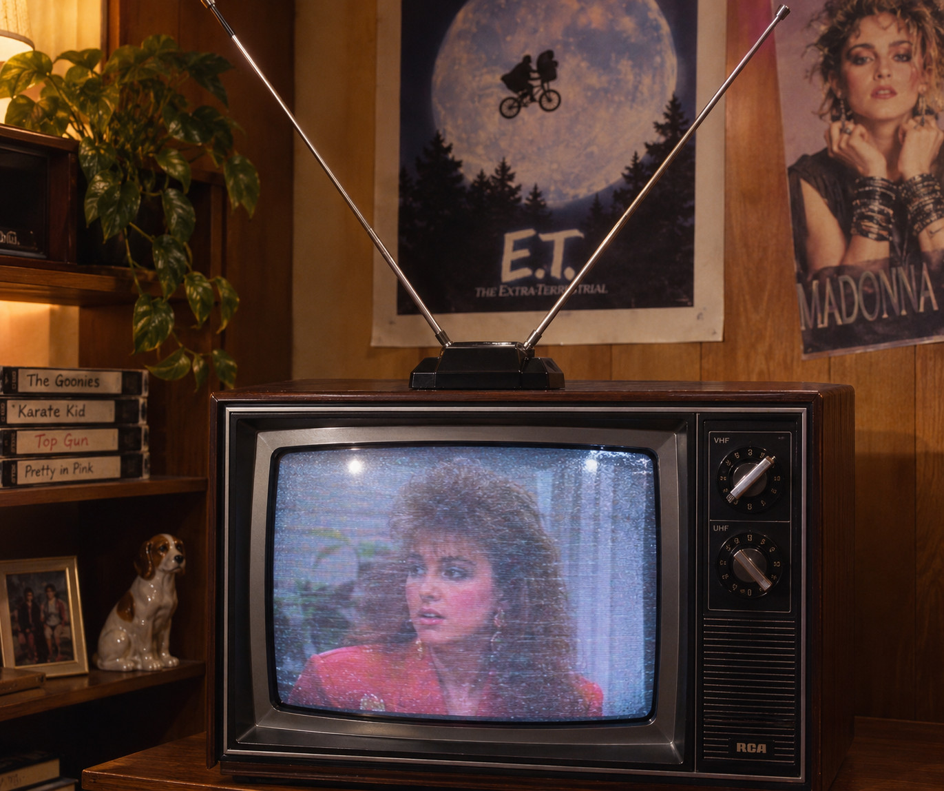 A vintage TV shows a woman with big hair in a red outfit. Behind the TV are posters for “E.T.” and Madonna, a plant, shelves with VHS tapes, and a ceramic dog. The scene has a retro 1980s vibe.