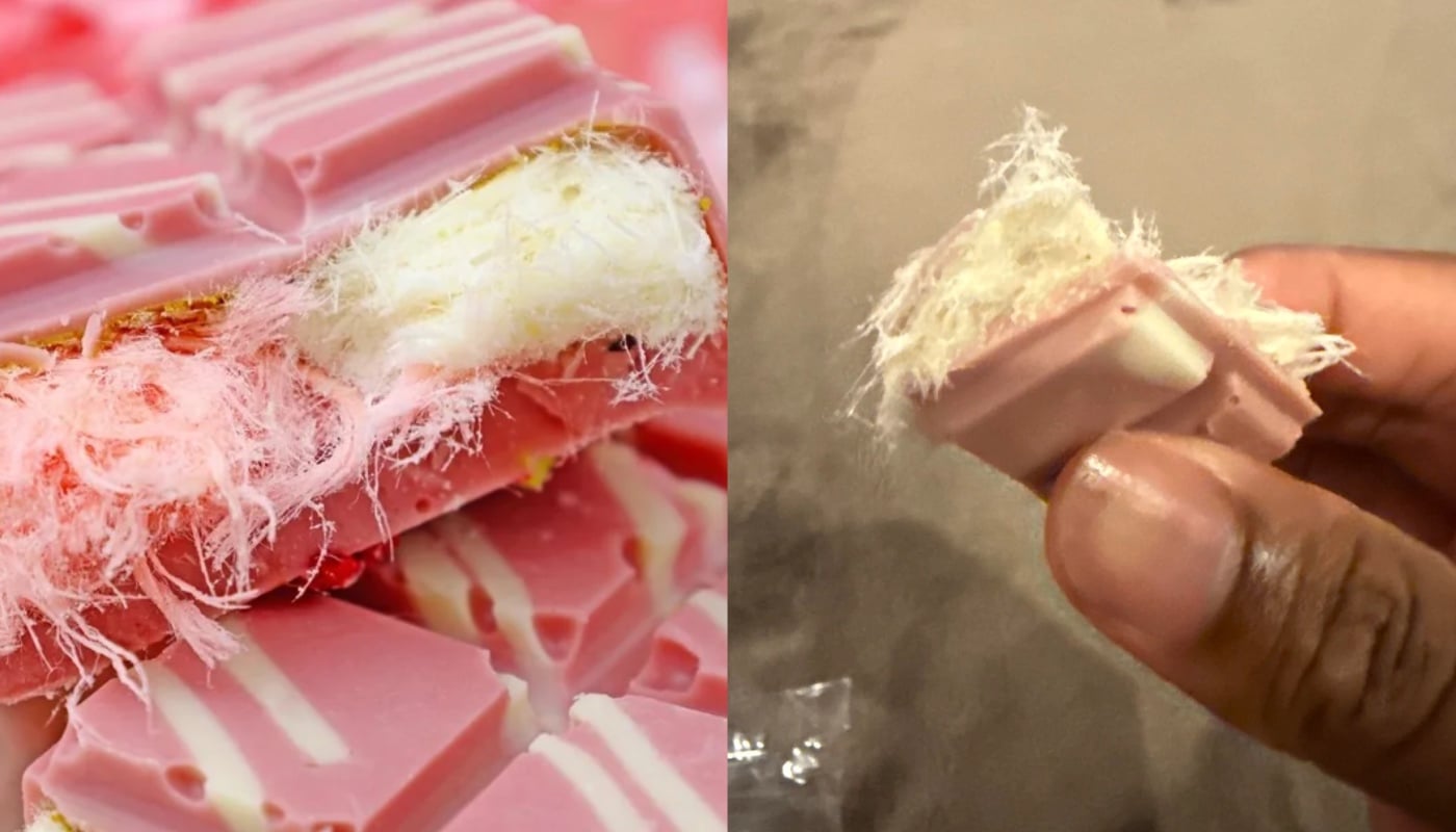 Close-up of pink chocolate pieces filled with a fluffy, white, fibrous center. On the right, a hand holds one piece, showing the texture of the filling clearly.