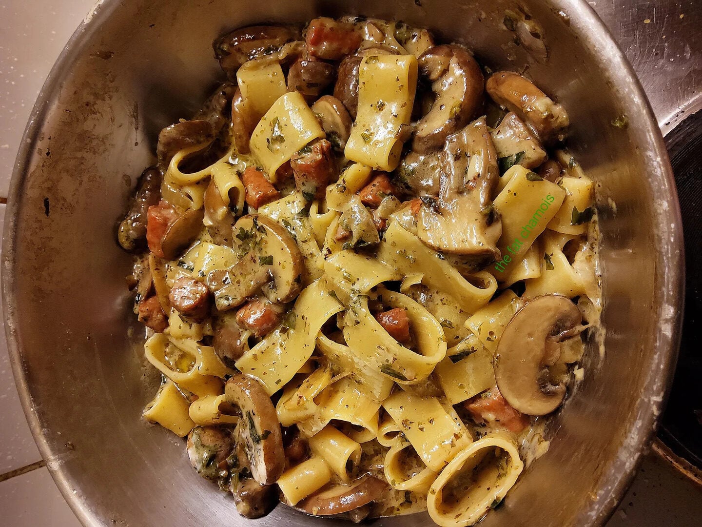 A bowl of creamy pasta with wide noodles, mushrooms, herbs, and pieces of what appears to be sausage, all mixed together—just the kind of dish you’d find in enticing photos of pasta.