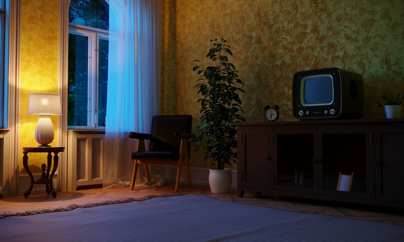 A warmly lit vintage room with a lamp, armchair, potted plant, and an old television on a wooden cabinet beside a window with sheer curtains.