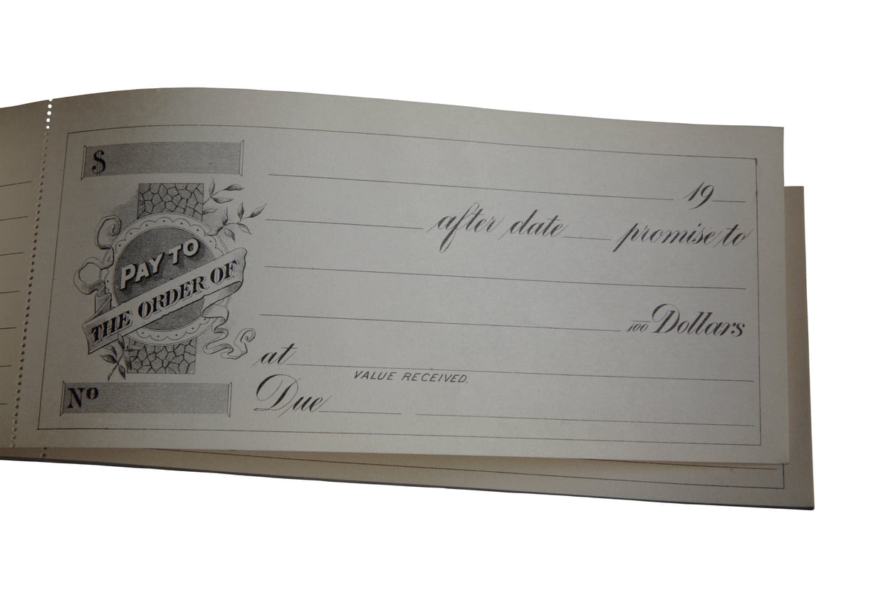 A blank check with fields for payee, date, dollar amount, and signature—perfect for gifting a vacation—with the text “Pay to the order of” on the left side.