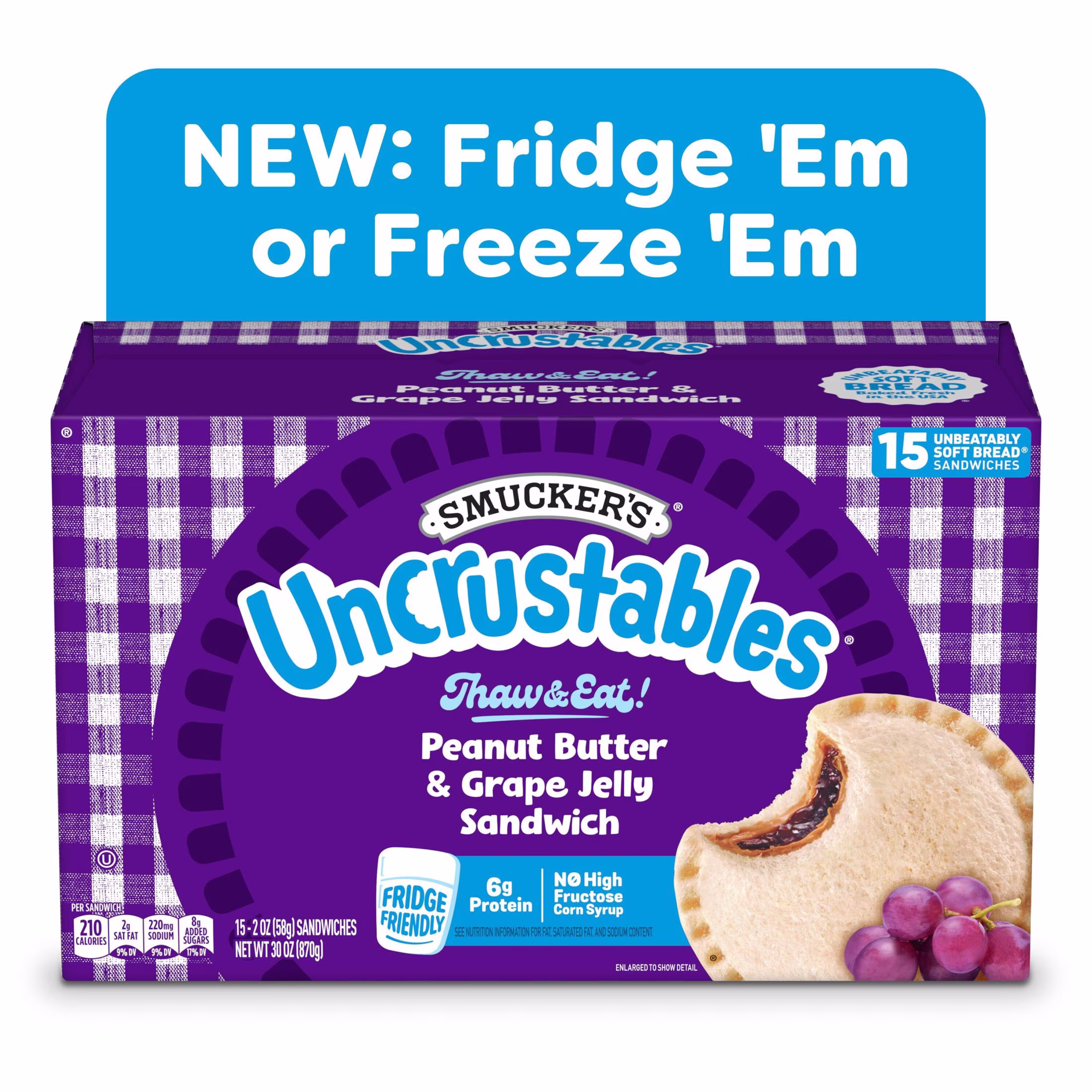 A box of Smucker’s Uncrustables Peanut Butter & Grape Jelly Sandwiches shows a sandwich with grape filling. Text above says “NEW: Fridge ’Em or Freeze ’Em.” The box contains 15 sandwiches.