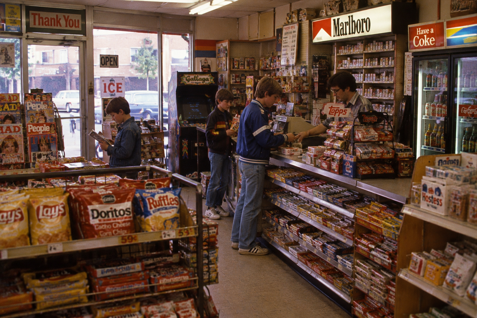 Two boys browse snacks while another pays a clerk at the counter of a convenience store.