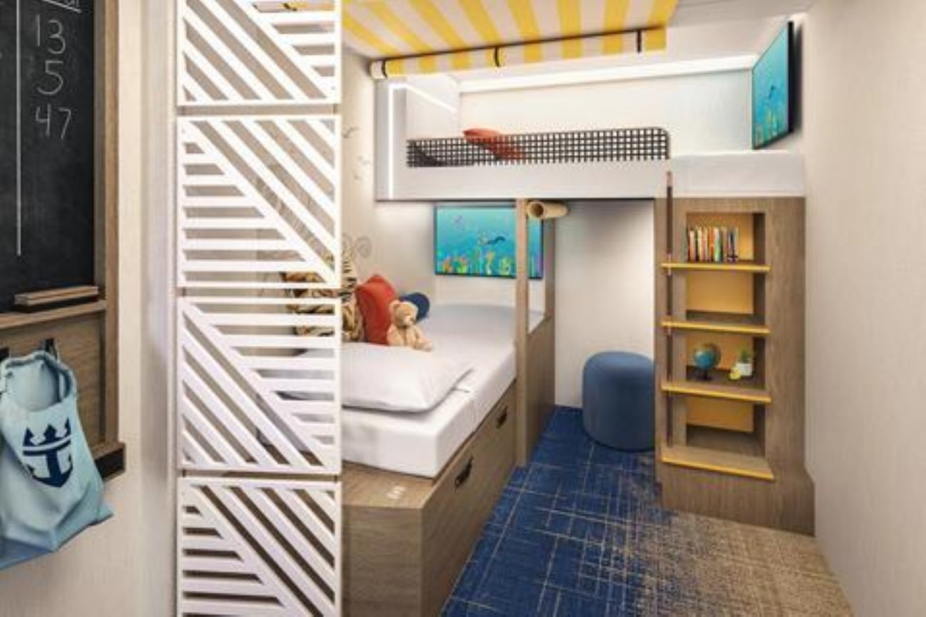 A cruise ship cabin for children featuring a bunk bed, a small desk area with shelves, and a decorative privacy screen.