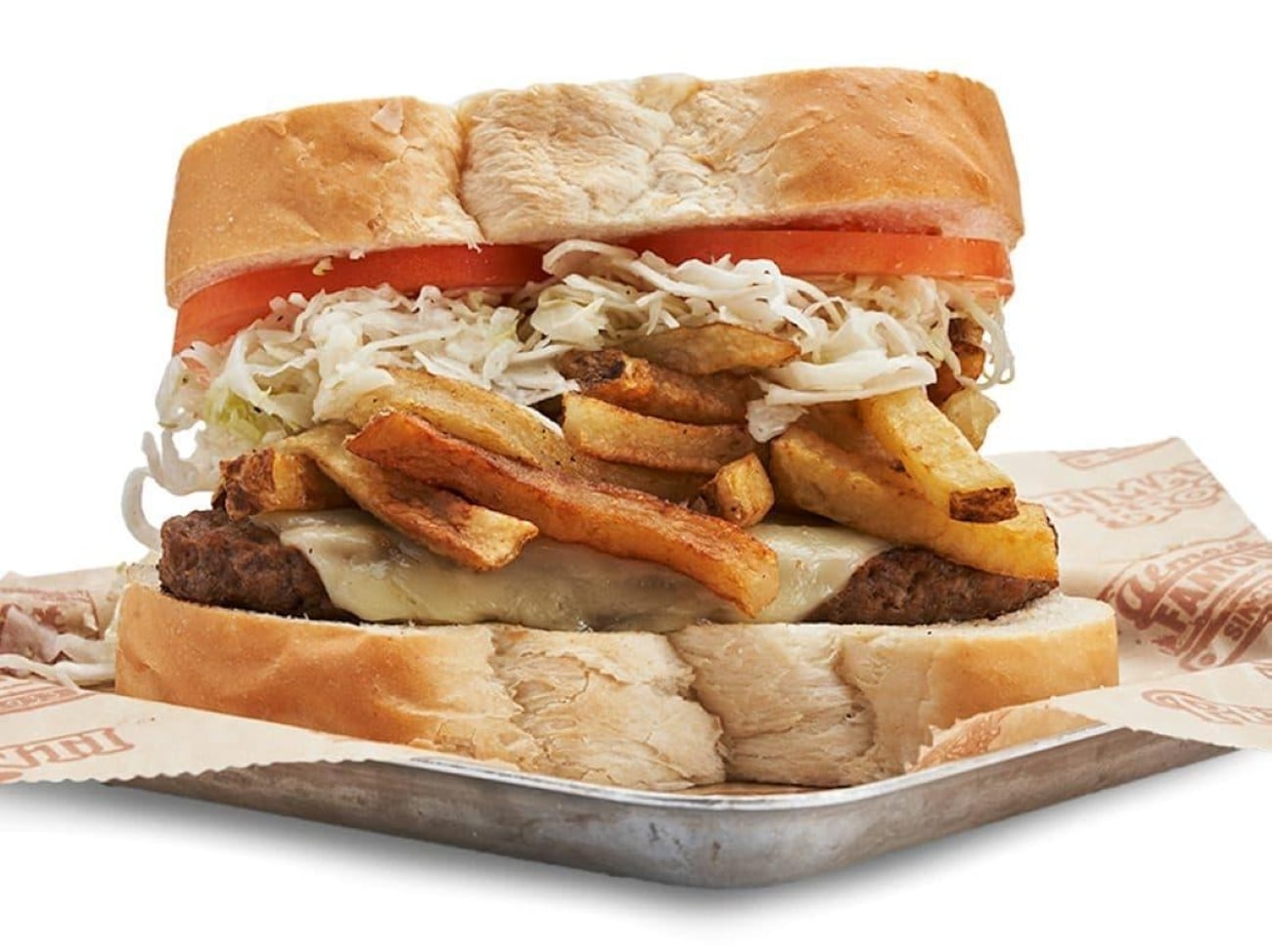 A sandwich on thick white bread layered with a burger patty, melted cheese, french fries, coleslaw, and tomato slices.