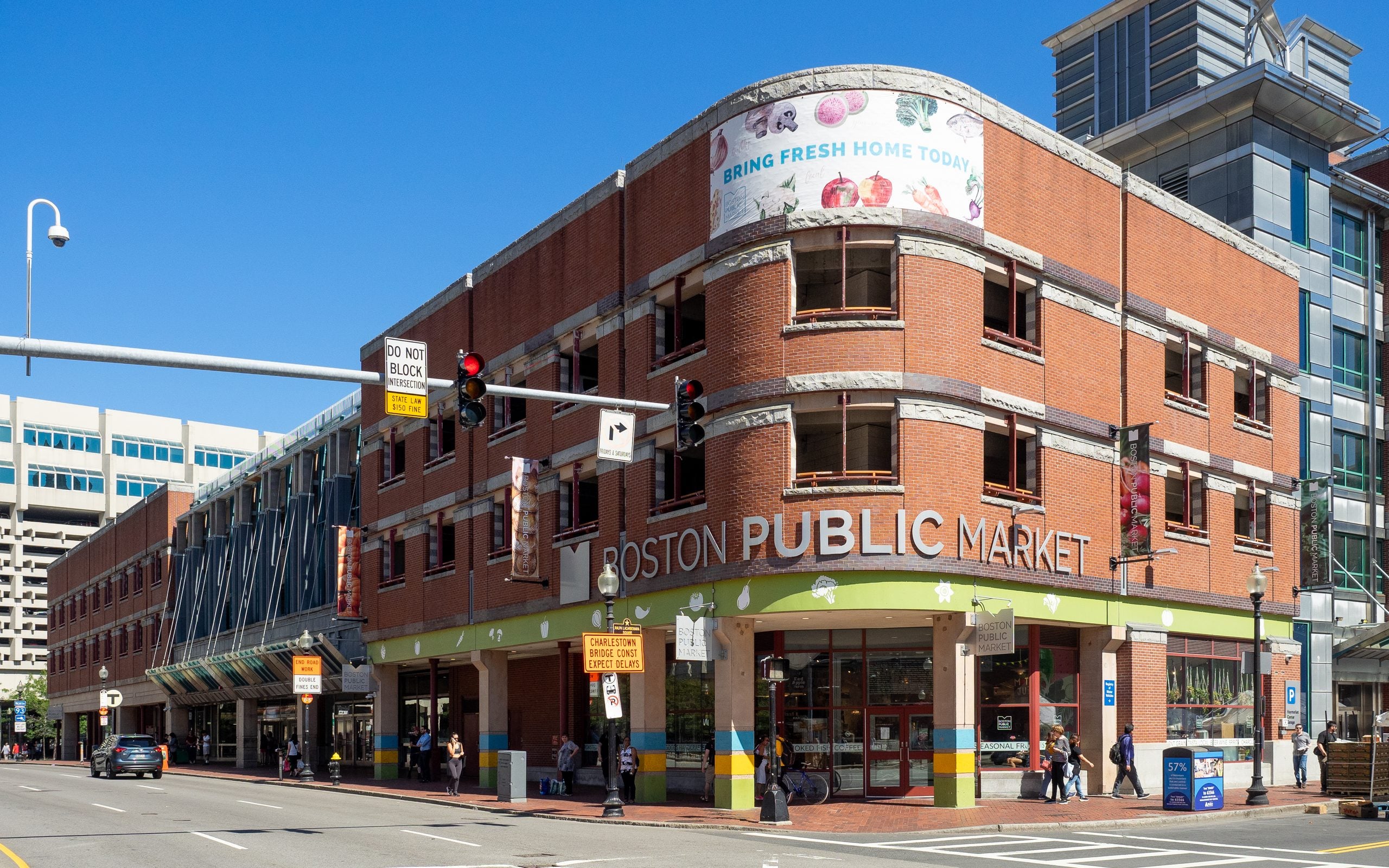 The Boston Public Market building on a corner street, featuring a brick facade with the market’s name in large letters above the entrance.