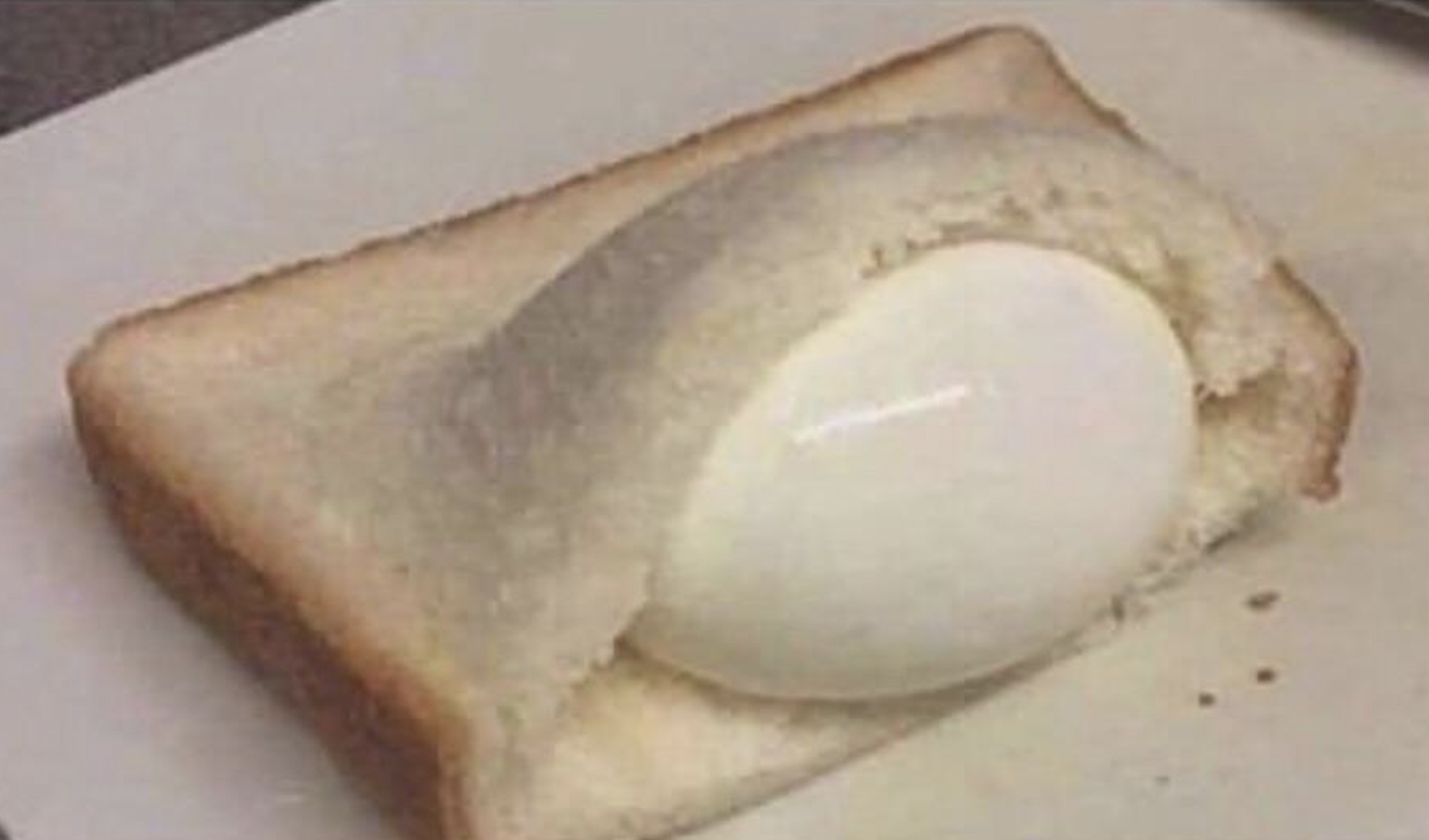 A hard-boiled egg tucked into a single slice of white bread.