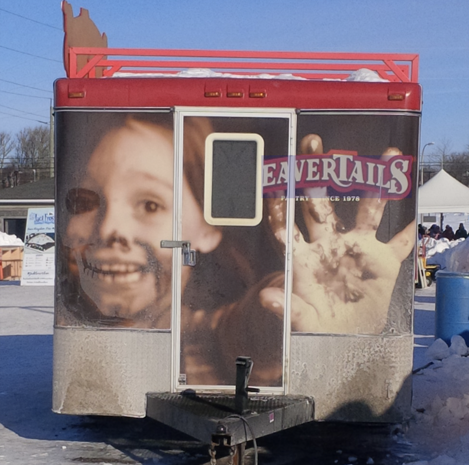 BeaverTails food trailer featuring a large graphic of a smiling child with chocolate on their face and a chocolate-covered hand.