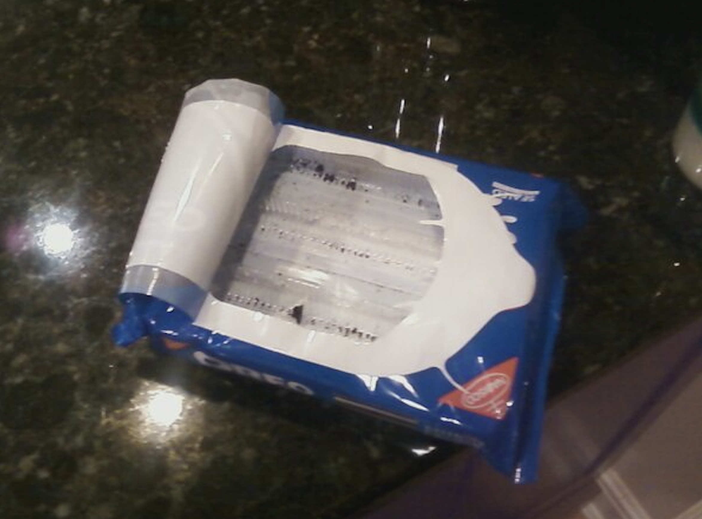 A package of Oreo cookies with the top film peeled back to reveal the plastic tray inside.