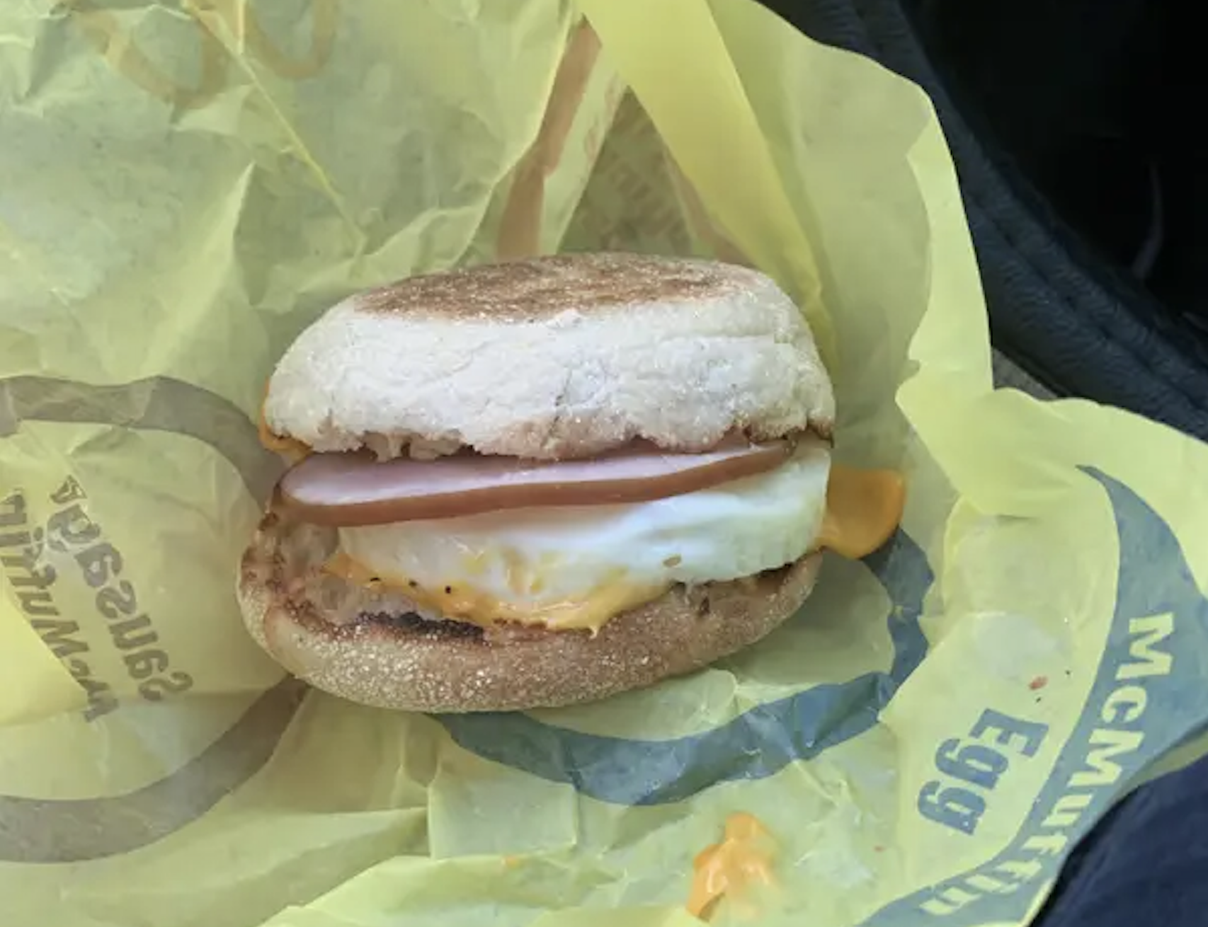 A McDonald’s Egg McMuffin sandwich resting on its yellow branded wrapper.